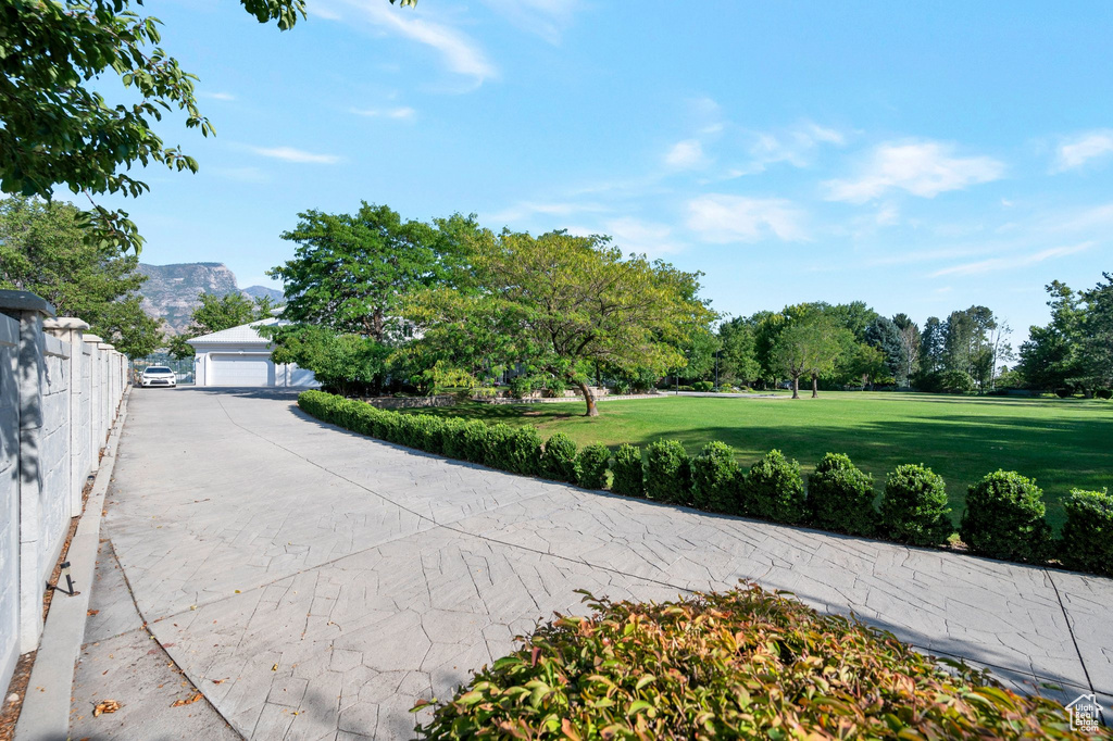 Surrounding community featuring a mountain view, a yard, and a garage