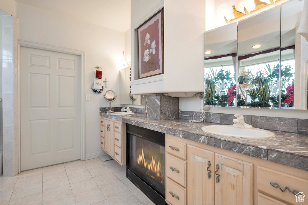 Bathroom with tile patterned floors, backsplash, and vanity