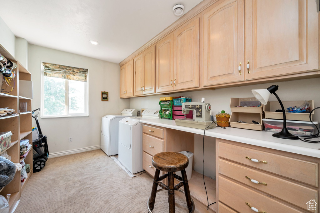 Washroom with light carpet, cabinets, and washer and dryer