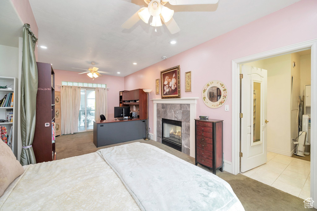 Tiled bedroom with ceiling fan and a fireplace