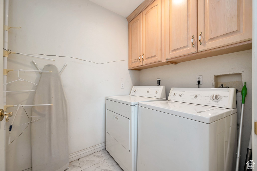 Laundry area featuring washing machine and clothes dryer and cabinets