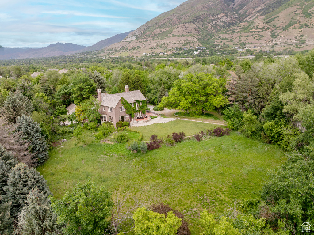 Aerial view of property and surrounding area featuring a mountainous background