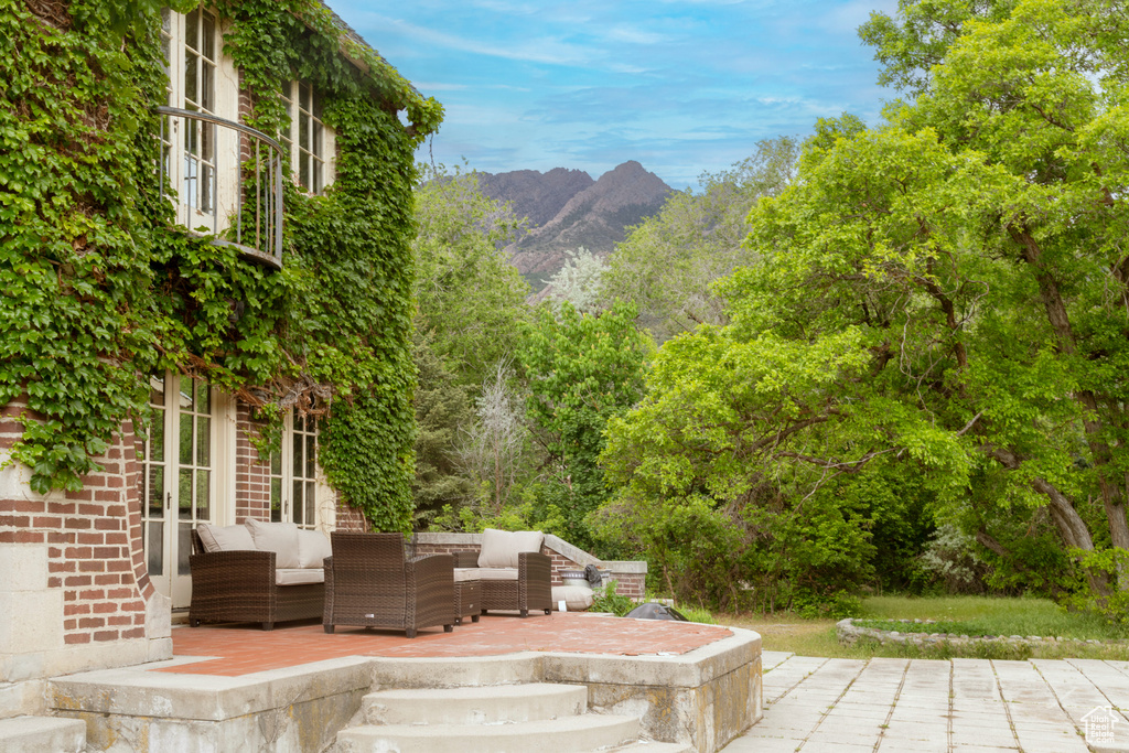 View of patio featuring an outdoor hangout area, a mountain view, and french doors