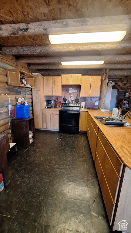 Kitchen with black range with electric cooktop, beamed ceiling, and log walls