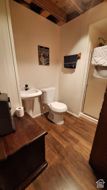 Bathroom featuring a shower with door, toilet, beamed ceiling, and hardwood / wood-style flooring