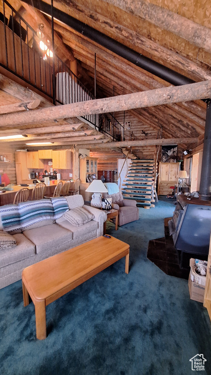 Interior space with beam ceiling, log walls, and carpet floors