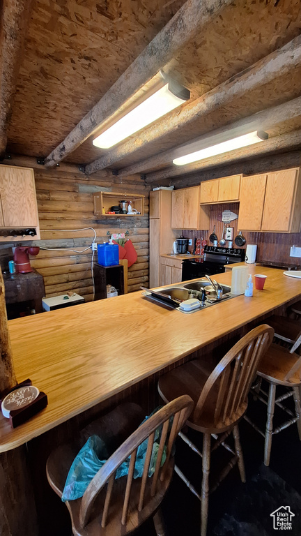 Kitchen featuring rustic walls, wood walls, black range with electric stovetop, and beam ceiling