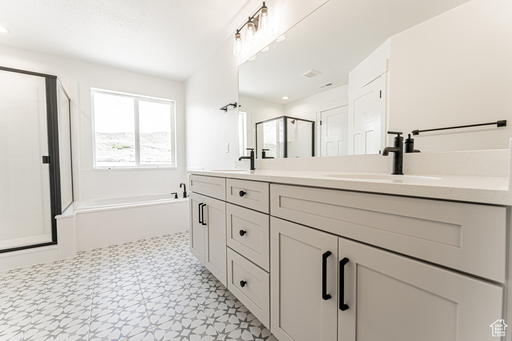 Bathroom featuring a stall shower, double vanity, a garden tub, tile patterned floors, and recessed lighting