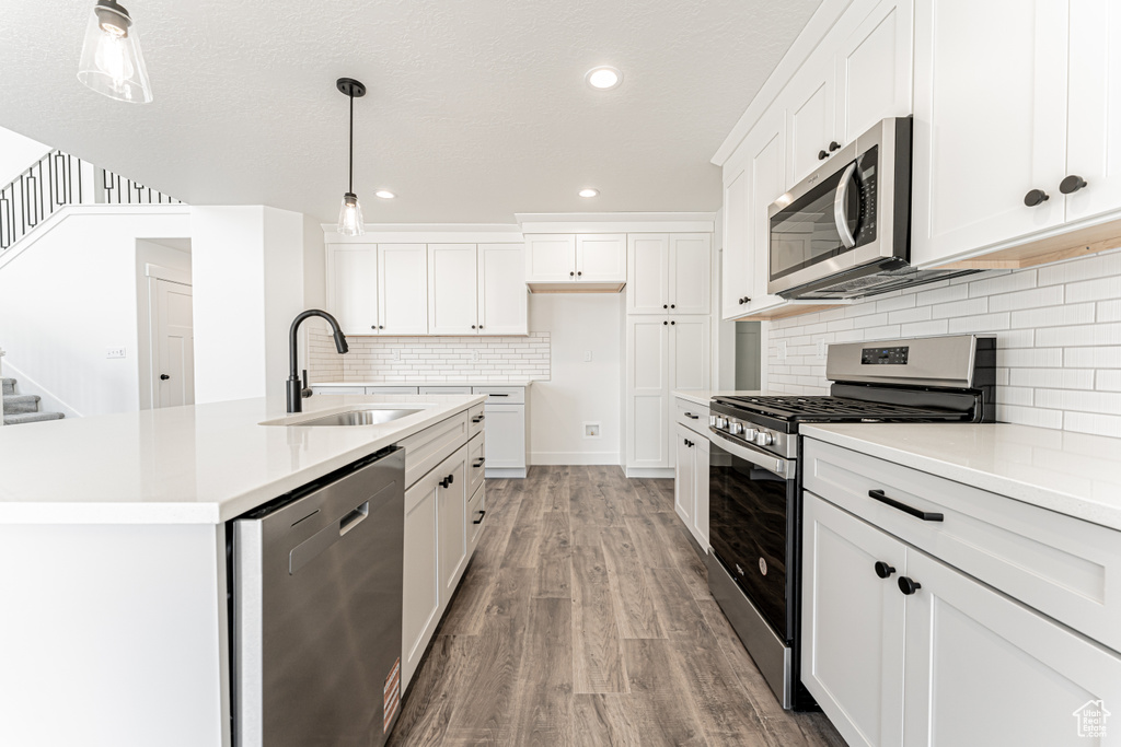 Kitchen featuring stainless steel appliances, a sink, light wood-style flooring, light countertops, and recessed lighting