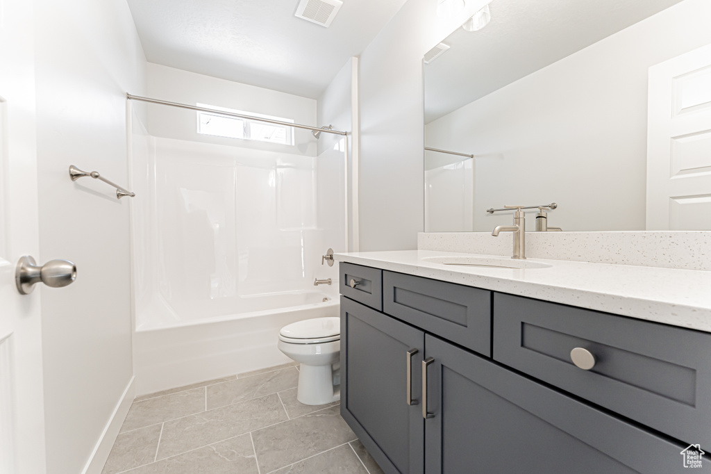 Full bath featuring vanity, toilet, tub / shower combination, and baseboards