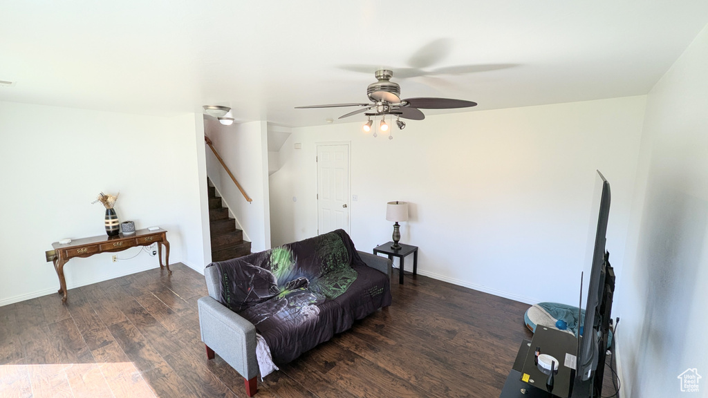 Living area with ceiling fan and dark hardwood / wood-style floors