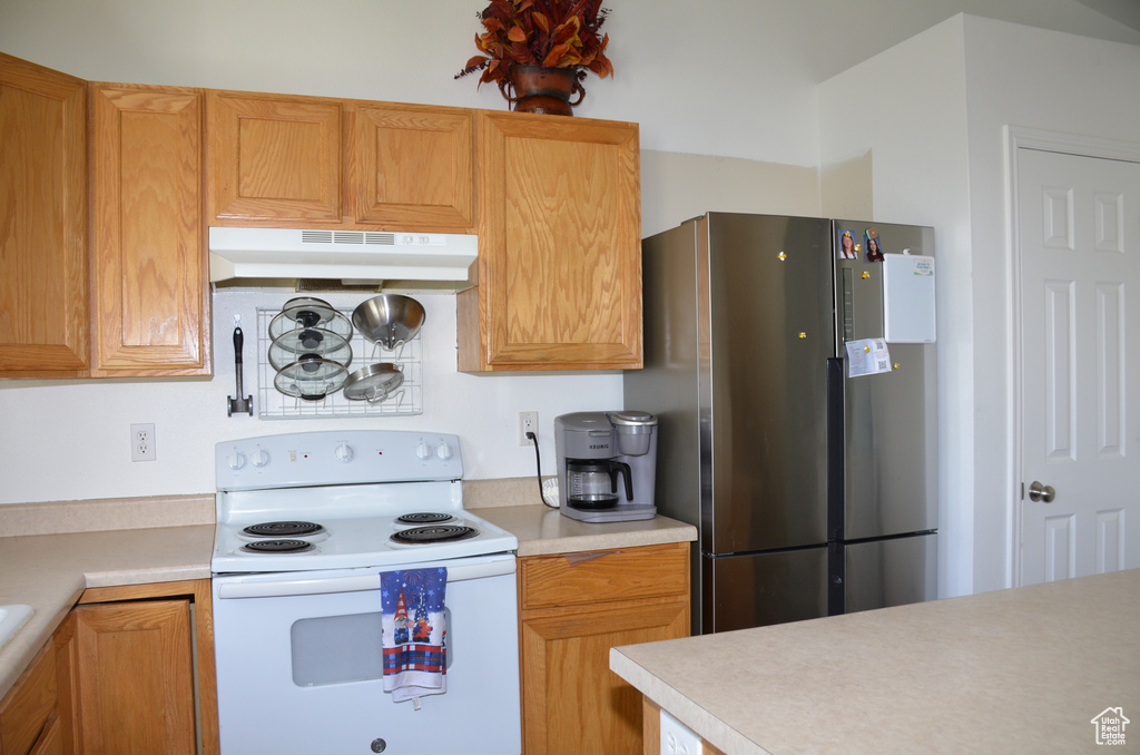 Kitchen with white electric stove and stainless steel fridge