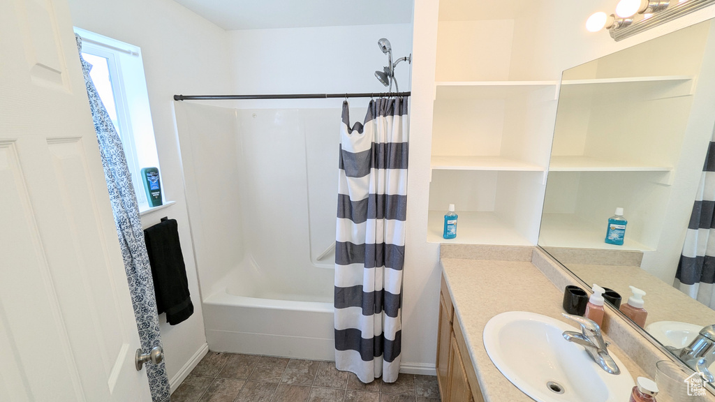 Bathroom featuring shower / bath combo, tile patterned flooring, and vanity