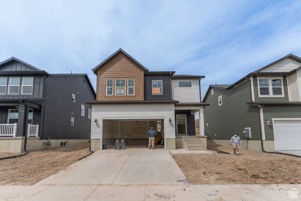 Craftsman inspired home featuring concrete driveway and an attached garage