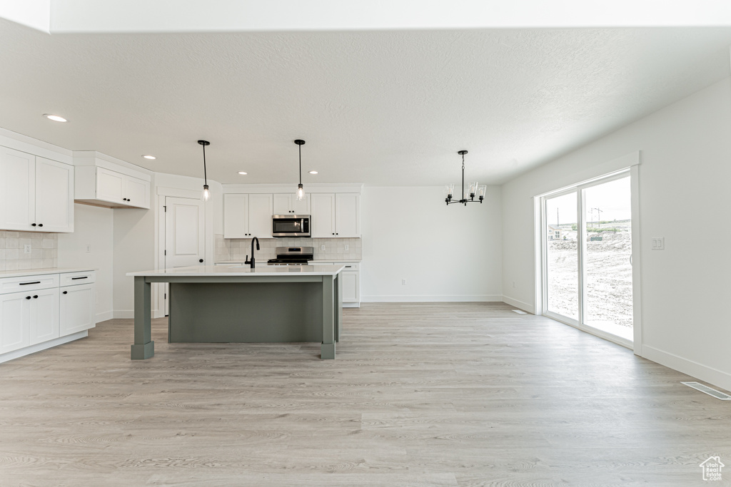 Kitchen with appliances with stainless steel finishes, decorative backsplash, light countertops, baseboards, and recessed lighting