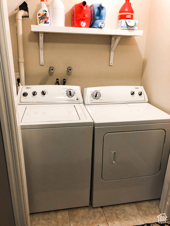 Laundry room with washer and dryer and light tile patterned flooring