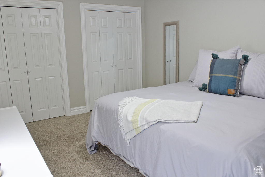 Carpeted bedroom featuring two closets