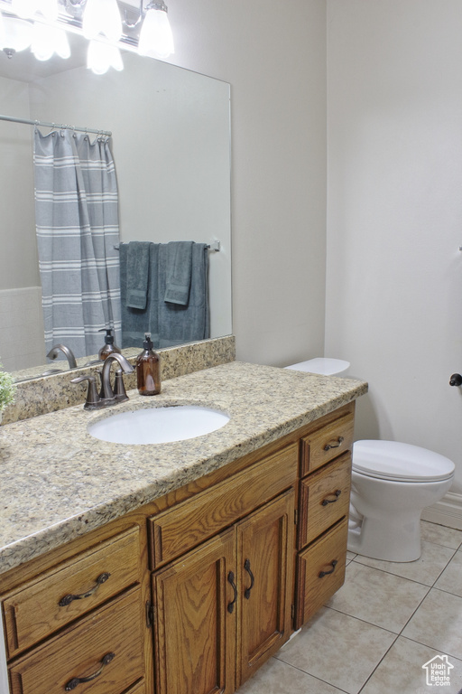 Bathroom with vanity, toilet, a shower with curtain, and tile patterned flooring