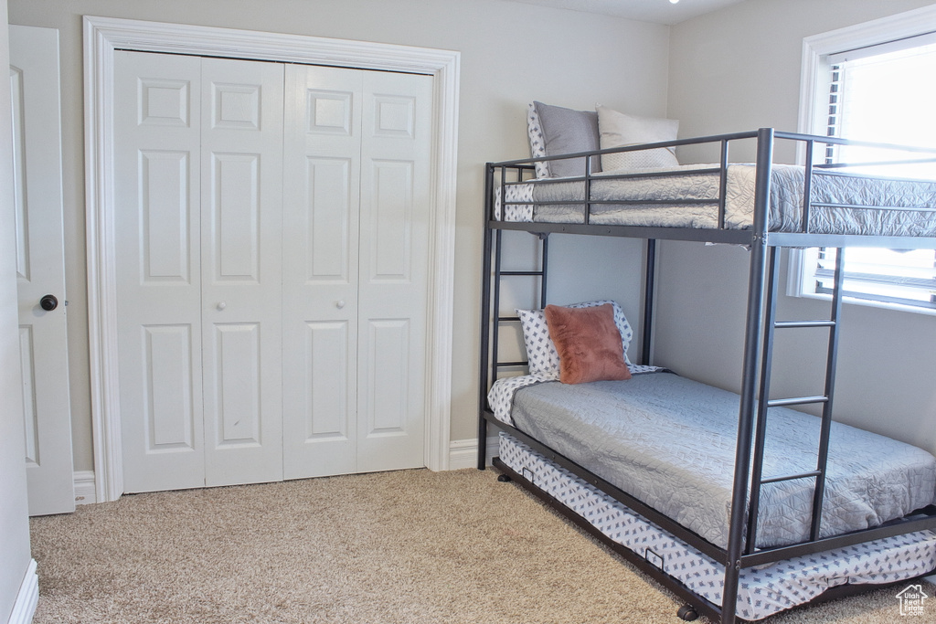 Carpeted bedroom with a closet