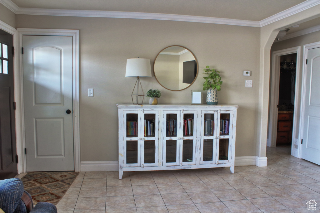 Tiled entrance foyer featuring crown molding