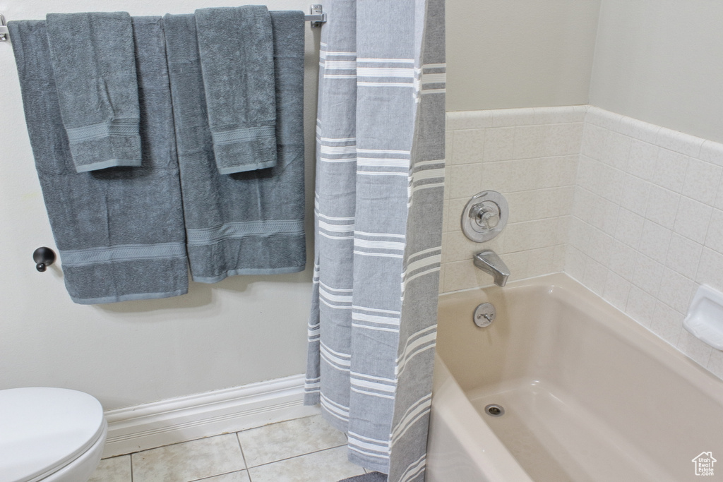 Bathroom with tile patterned flooring, toilet, and shower / bath combo