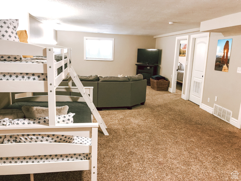 Bedroom with a textured ceiling and carpet