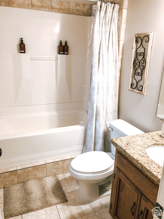 Full bathroom with tile patterned flooring, vanity, toilet, and shower / bath combination with curtain