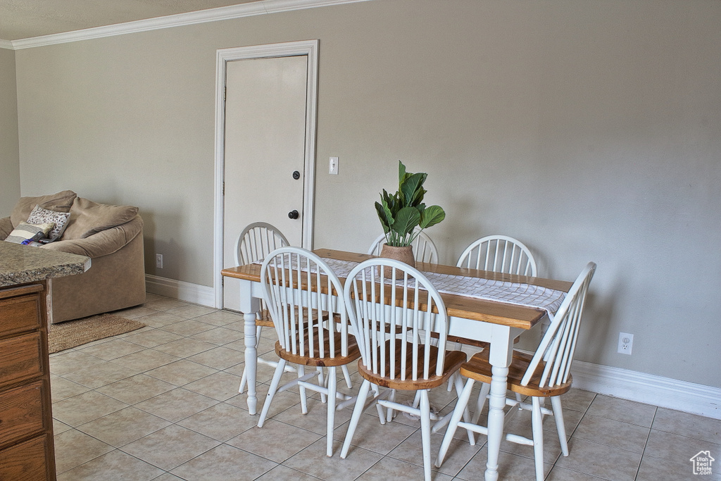 Dining area with crown molding and light tile patterned floors