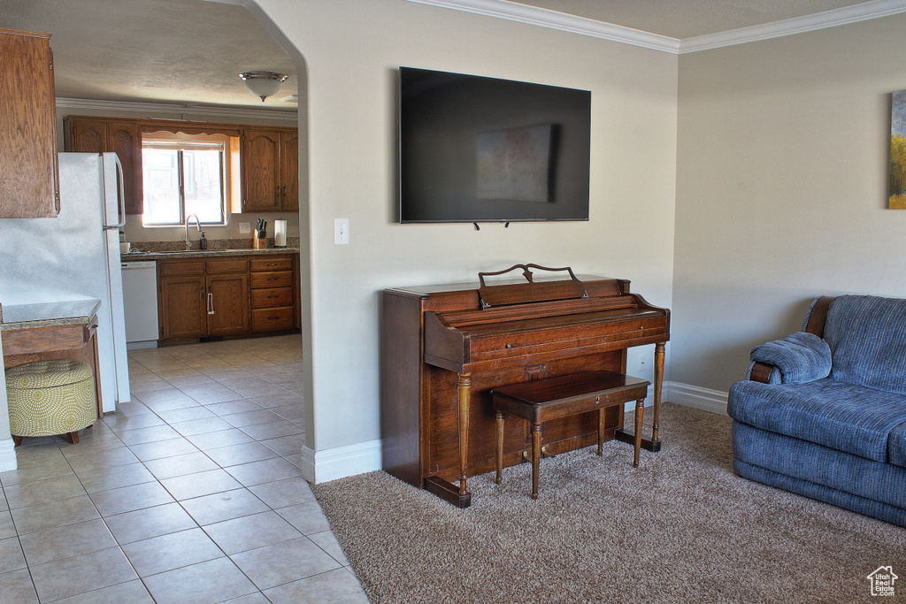 Interior space featuring light tile patterned floors, white dishwasher, crown molding, and sink