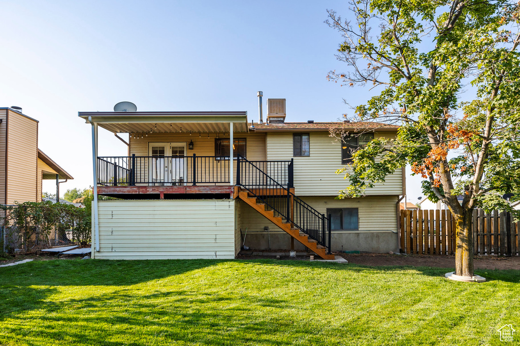 Back of property featuring a yard and a deck