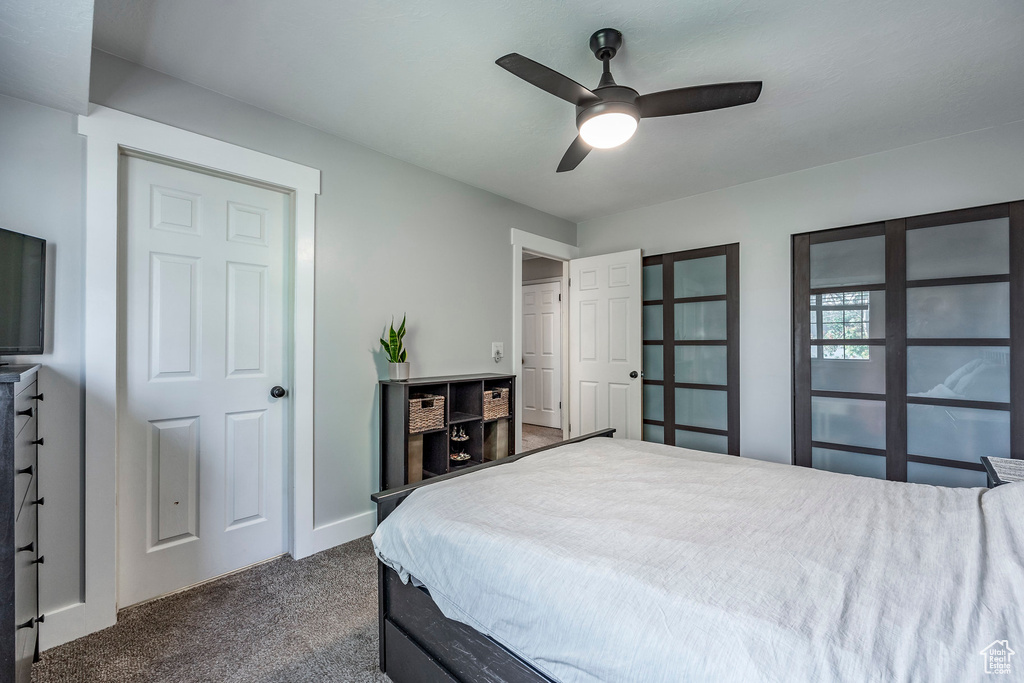 Bedroom featuring ceiling fan and dark colored carpet