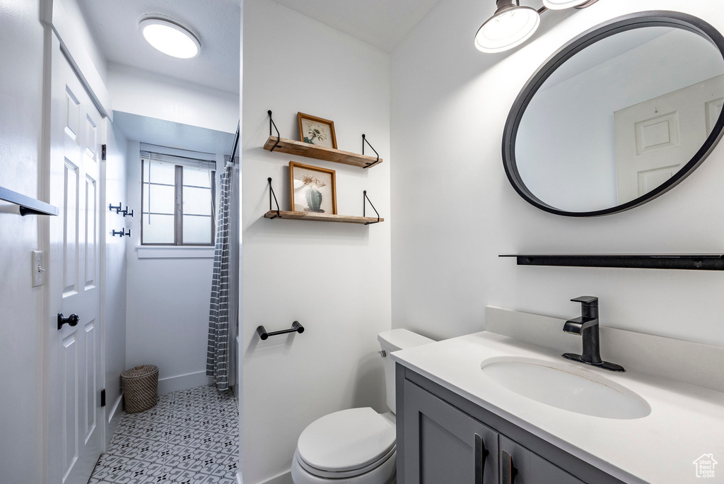 Bathroom with tile patterned flooring, toilet, and vanity