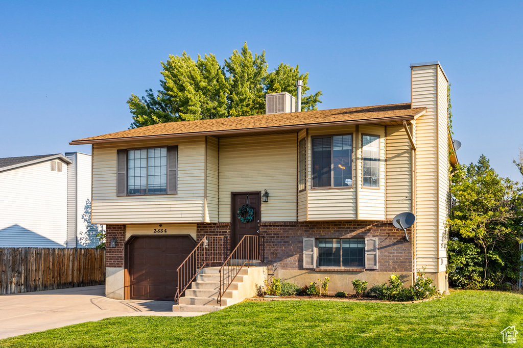 Raised ranch with a garage and a front lawn