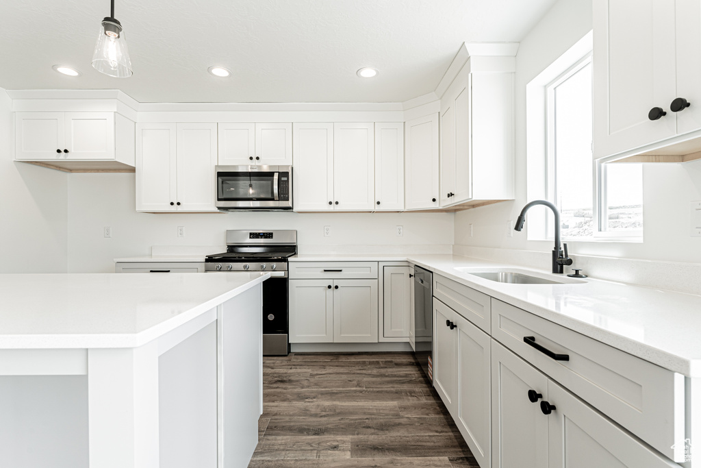 Kitchen featuring appliances with stainless steel finishes, a sink, dark wood-style floors, white cabinetry, and recessed lighting