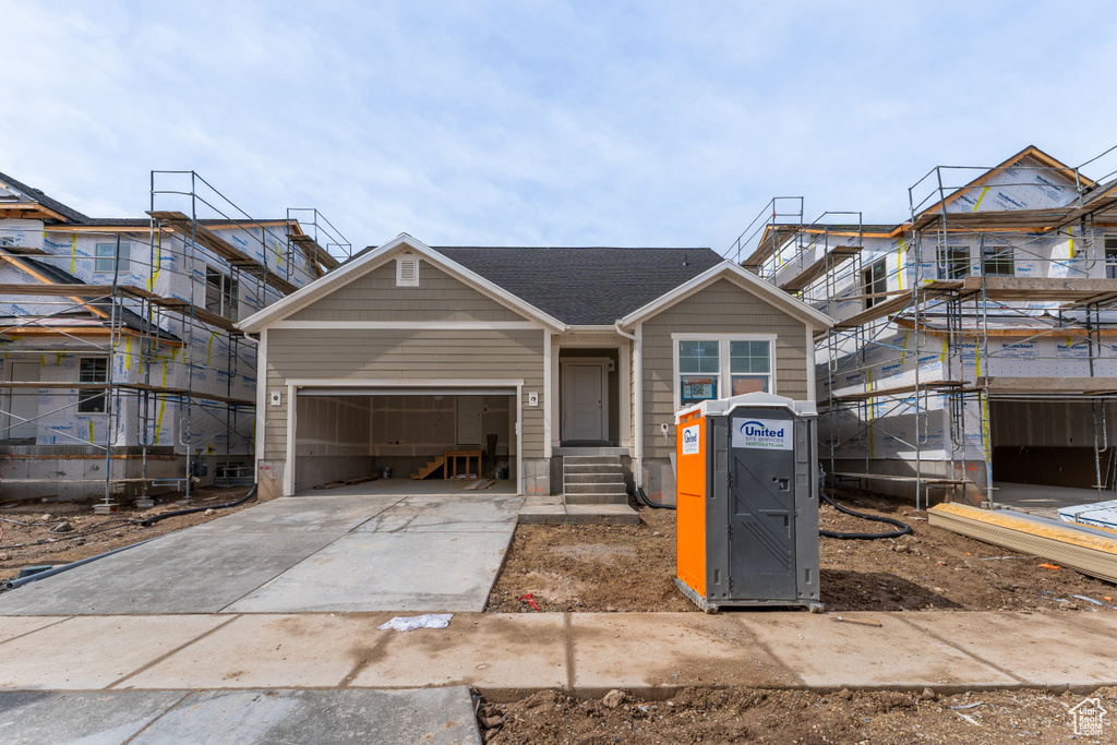 View of front of home featuring entry steps, driveway, and an attached garage