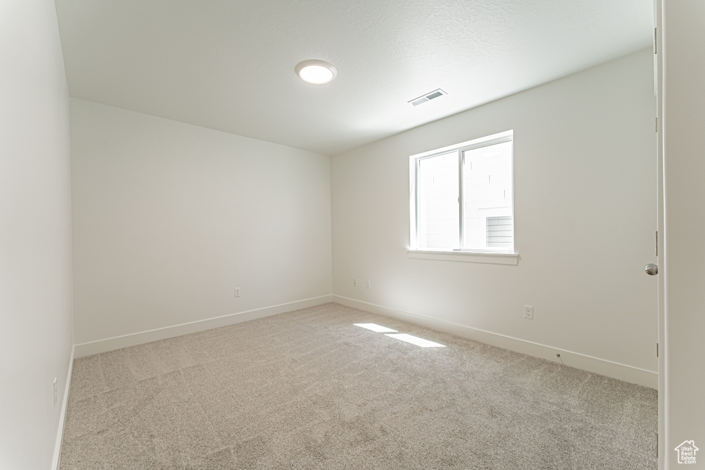 Carpeted spare room with baseboards