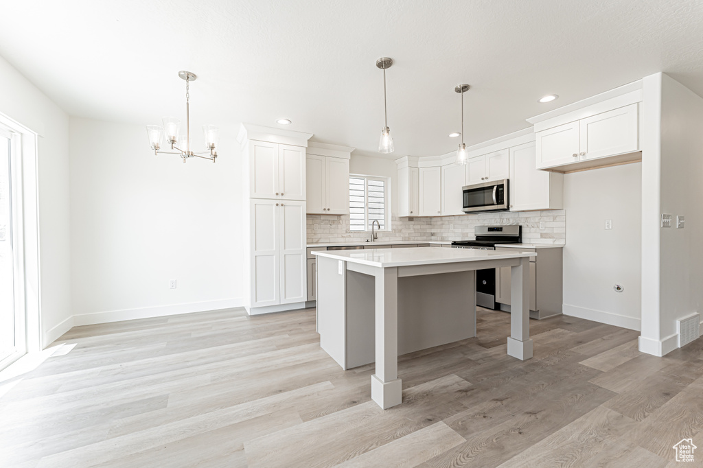 Kitchen featuring appliances with stainless steel finishes, a sink, backsplash, recessed lighting, and light countertops