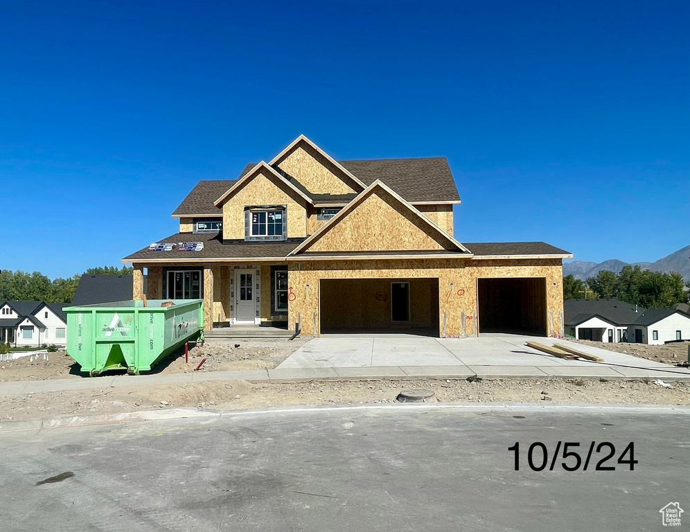 View of front of home with a mountain view and a garage