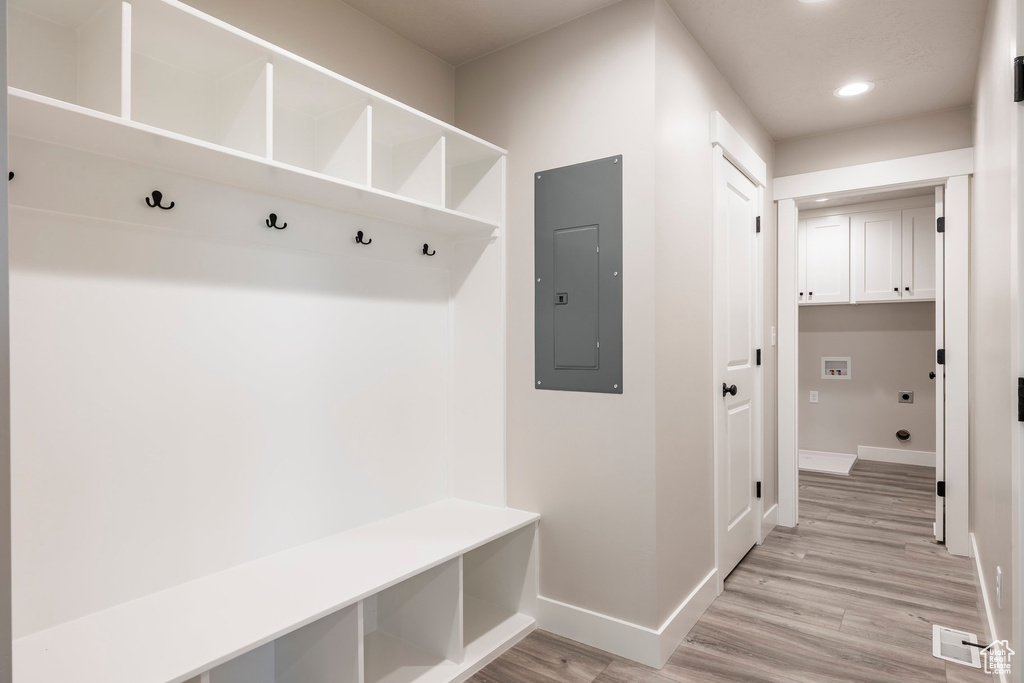 Mudroom with electric panel and light wood-type flooring