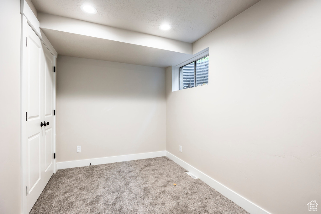 Carpeted spare room featuring a textured ceiling