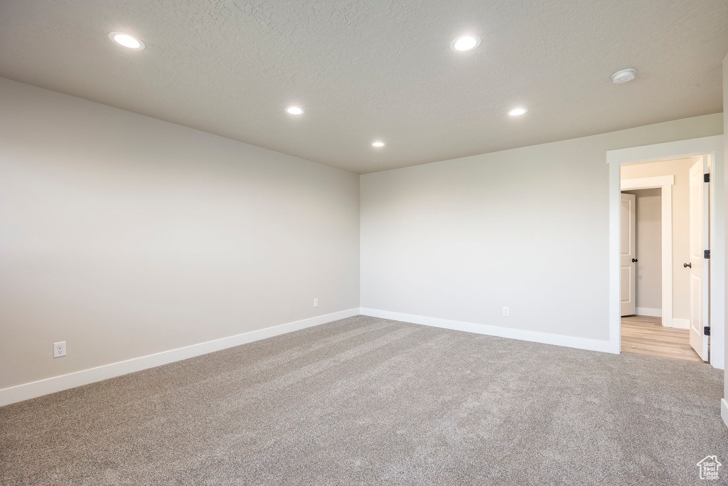 Carpeted empty room with a textured ceiling