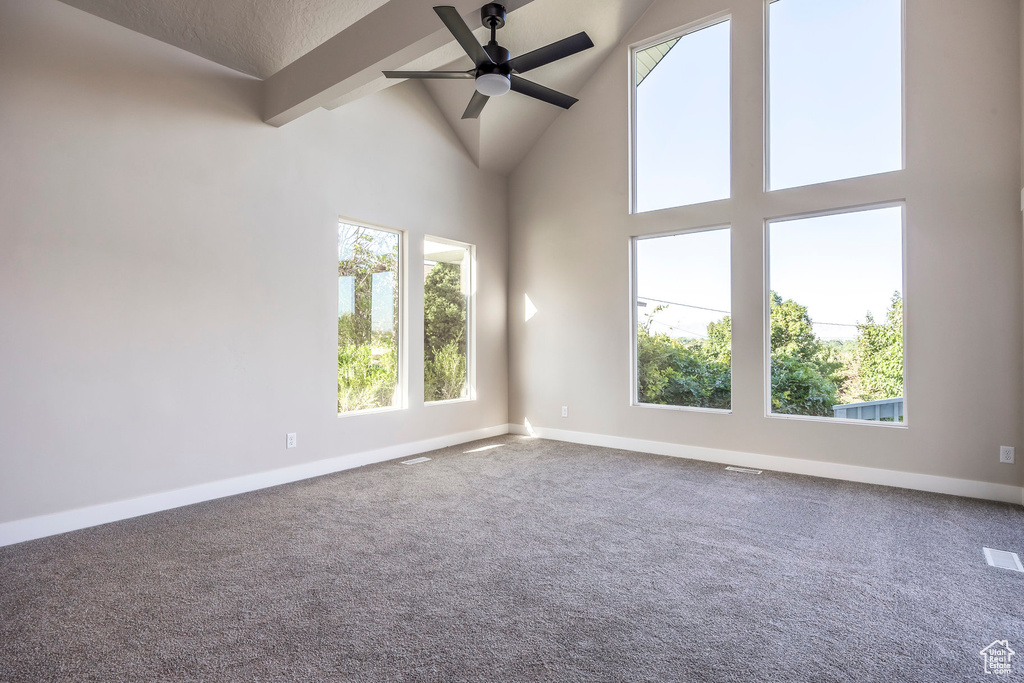 Unfurnished room with beamed ceiling, ceiling fan, high vaulted ceiling, and carpet