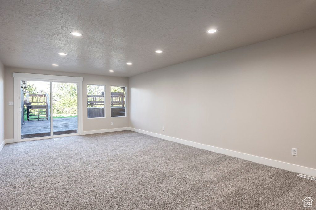 Carpeted empty room featuring a textured ceiling