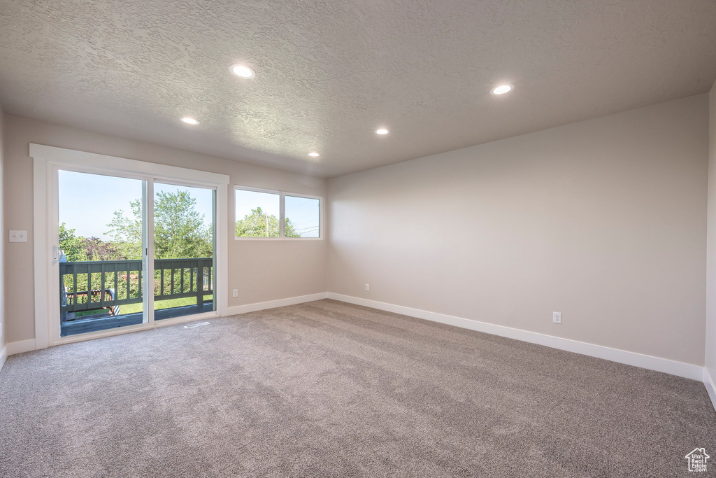 Carpeted spare room with a textured ceiling