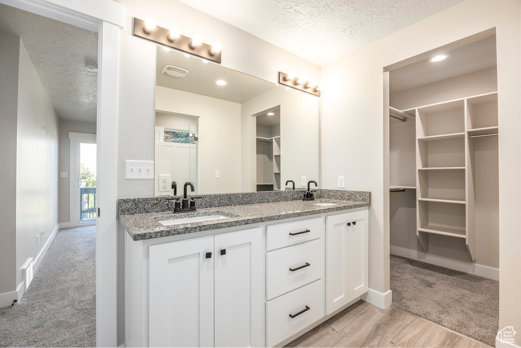 Bathroom with vanity, a textured ceiling, and wood-type flooring