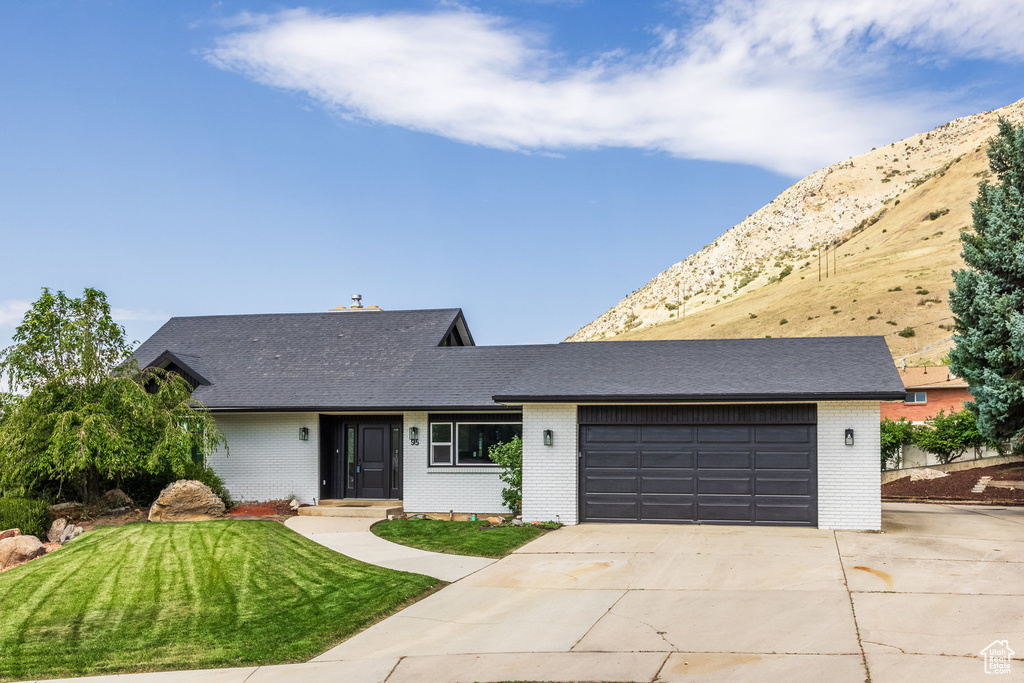 Ranch-style home featuring a garage and a front yard