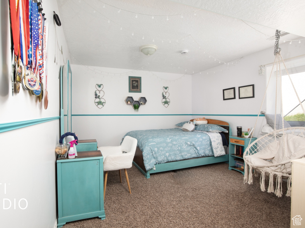 Bedroom with a textured ceiling and carpet flooring