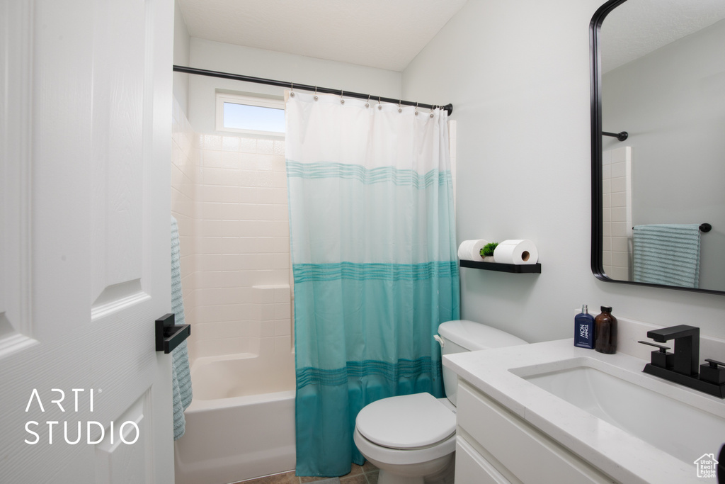 Full bathroom with shower / bathtub combination with curtain, toilet, and vanity