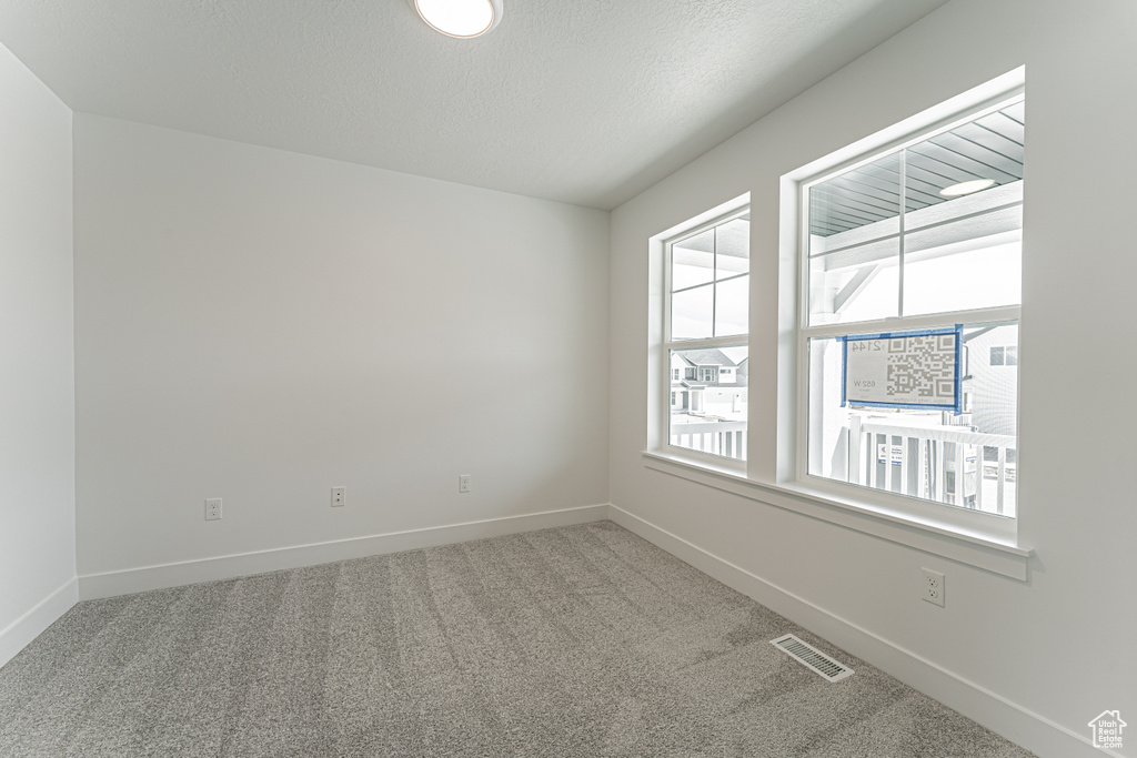 Spare room featuring carpet flooring and baseboards