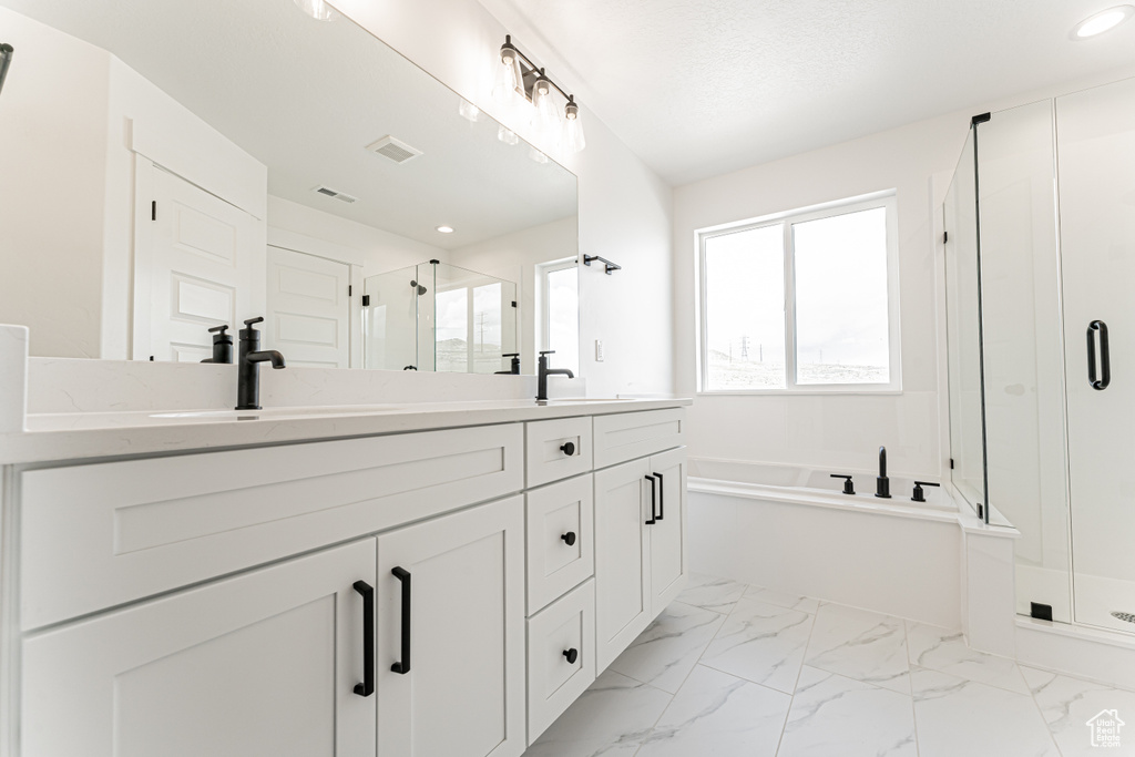 Full bathroom featuring a stall shower, double vanity, a bath, marble finish floors, and recessed lighting
